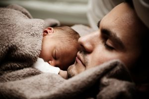 A baby adopted from a local adoption agency sleeping on his father's chest.